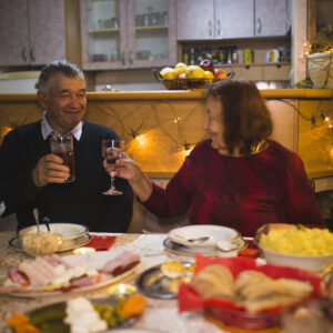 Happy senior couple in love, husband and wife toasting during family dinner and celebrate holidays at home